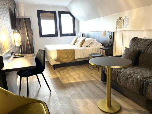 a hotel room with a bed and a couch at Logis - Hôtel de la Baie de Somme in Le Crotoy