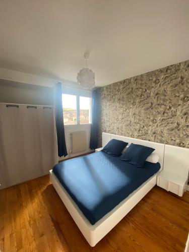 - une chambre dotée d'un grand lit avec des draps bleus dans l'établissement Appartement spacieux avec parking, à Lempdes