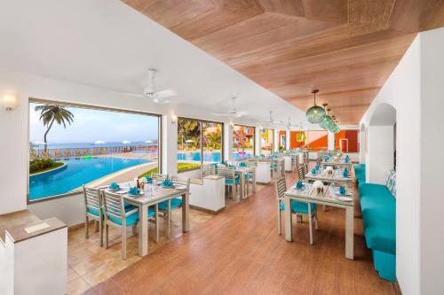 a dining room with tables and chairs and a pool at Taj Cidade de Goa Heritage, Goa in Panaji