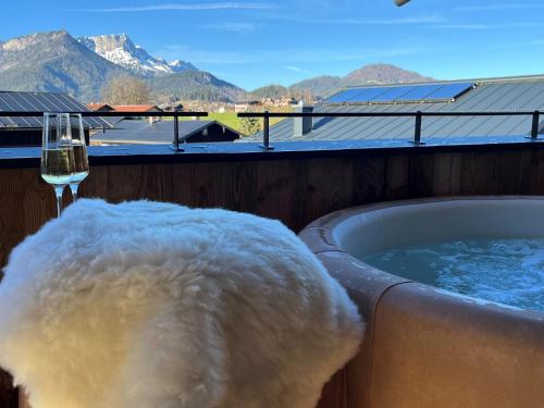 a tub filled with snow next to a glass of wine at Alpenlodges in Schönau am Königssee