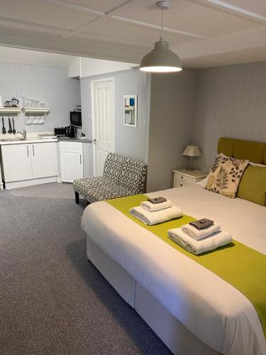a bedroom with a large bed with towels on it at Petherton Cottage Studios in Ringwood
