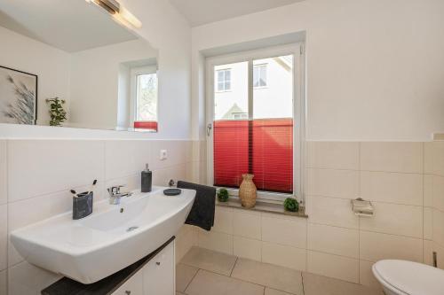 コルスヴァントにあるFerienhaus Sonne 6cの白いバスルーム(シンク、窓付)
