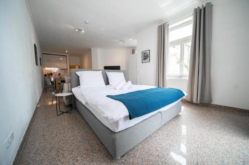 a bedroom with a large bed with a blue blanket at Apartments - Kitchen & More in Düsseldorf