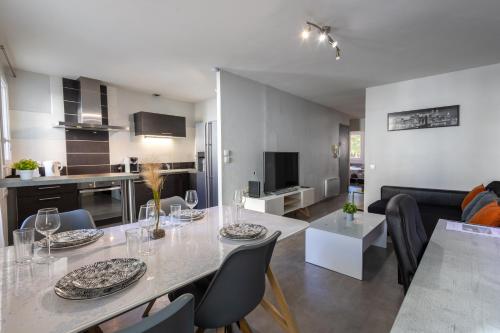 une salle à manger et une cuisine avec une table et des chaises dans l'établissement L'Évêché - T3 Spacieux & Traversant en Hypercentre, à Castres