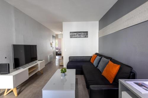- un salon avec un canapé et une télévision dans l'établissement L'Évêché - Grand T3 en hyper-centre, à Castres