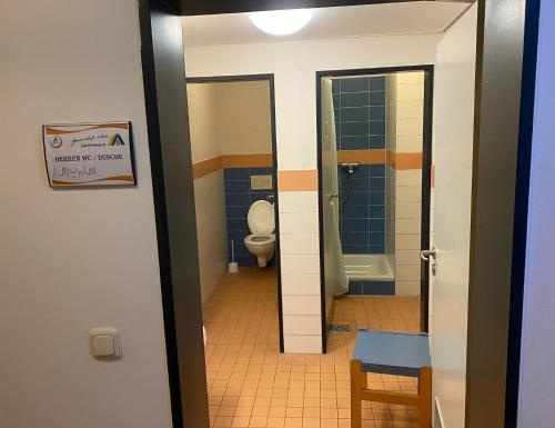 a bathroom with a toilet and a doorway at Jugendherberge Lübeck Altstadt in Lübeck