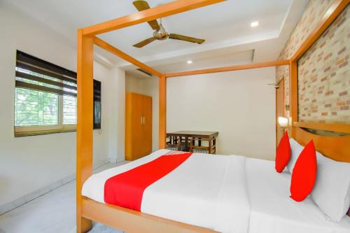 a bedroom with a bed with red pillows at Super OYO Krishna Guest House in Kolkata