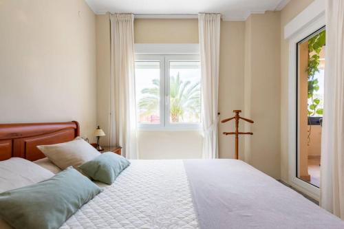 una camera da letto con un grande letto e una finestra di Playa de Los Álamos-Playamar Torremolinos Málaga. a Torremolinos