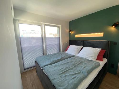 een bed in een slaapkamer met een groene muur bij Moselblick Penthouse mit Terrasse in Koblenz