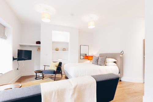 a bedroom with two beds and a tv at South Street Apartments in Chichester