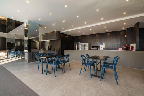 a restaurant with blue chairs and tables and a counter at Hotel Haus in Gapyeong