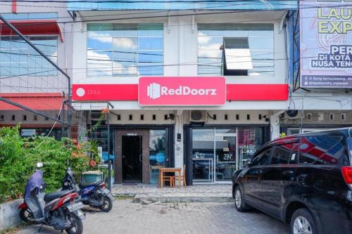 a red door store with a motorcycle parked in front of it at RedDoorz @ Just in Mataram City in Mataram