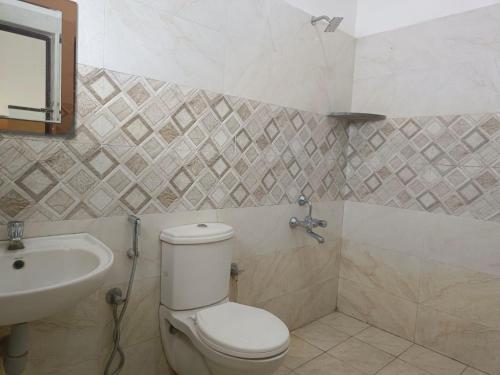 uma casa de banho com um WC e um lavatório em ARIVU LODGE AC em Coimbatore