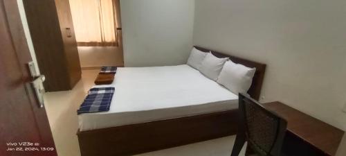 a bed in a small room with a wooden frame at ARIVU LODGE AC in Anaimalai
