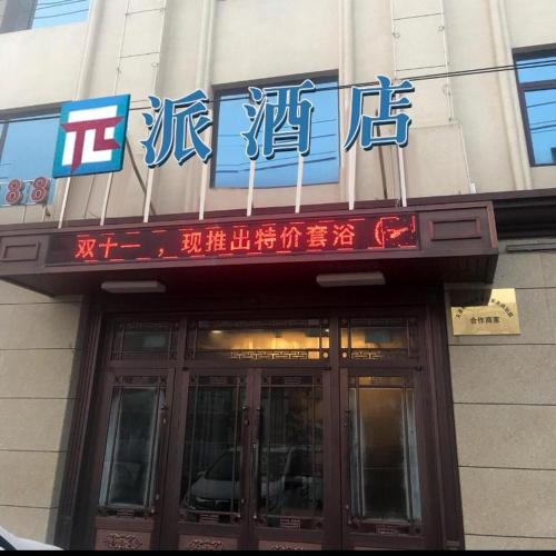a building with a sign above the door of a building at PAI Hotels Jinzhou Yi County Railway Station in Yi