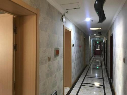 an empty hallway with a tile floor in a building at PAI Hotels Jinzhou Yi County Railway Station in Yi