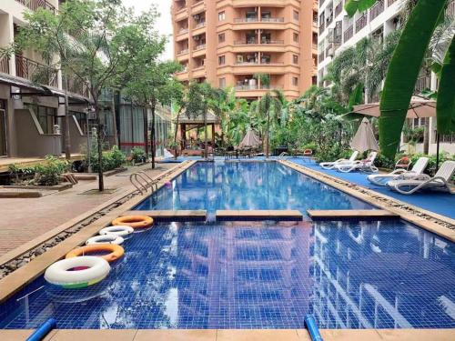 a large swimming pool with lounge chairs and a building at James Joyce Coffetel Xishuangbanna Gaozhuang Starlight Night Market in Jinghong