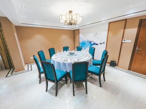 uma sala de conferências com uma mesa e cadeiras azuis em ZMAX Hotels Wuhan East Lake em Wuhan