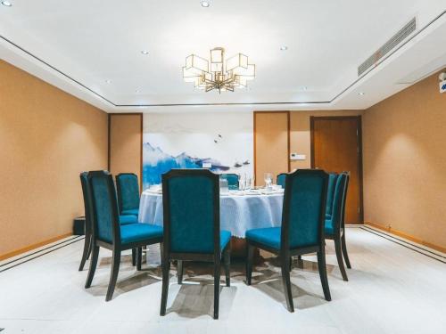uma sala de jantar com uma mesa e cadeiras e um lustre em ZMAX Hotels Wuhan East Lake em Wuhan