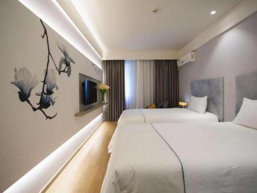 a hotel room with two beds and a tv at Magnotel Tai'an Luohe Park Luohe Street in Tai'an