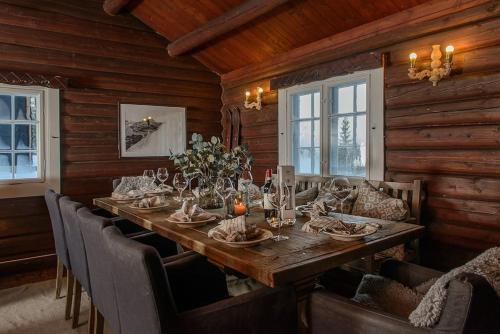 a dining room with a long wooden table and chairs at Koselig hytte 10 minutter fra Lillehammer sentrum in Lillehammer