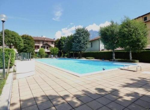 a large swimming pool in a yard with trees at Zen House in Domaso