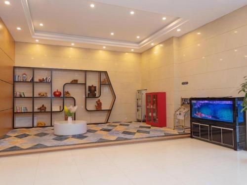 a large room with a television and a room with a floor at Chonpines Hotel Jining Quanmin Fitness Plaza in Jining