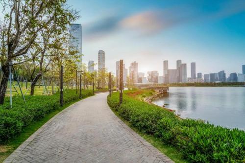 een pad in een park naast een waterlichaam bij Shenzhen Apex Hotel (Technology Park Branch) in Shenzhen
