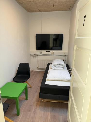 Habitación con cama, silla y TV. en Italian Rooms 7 en Aalborg