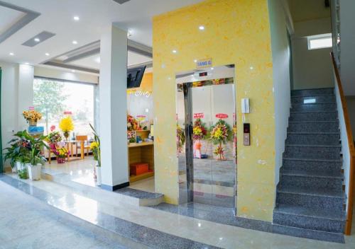 a lobby with a staircase and a yellow wall at Hong Ha Hotel in Pleiku Airport