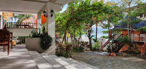 um alpendre de uma casa com árvores e uma varanda em Mt. Bagarabon Beach Hotel em Mabua