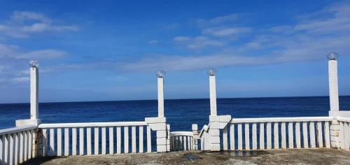 a white fence sitting on top of the ocean at Mt. Bagarabon Beach Hotel in Mabua
