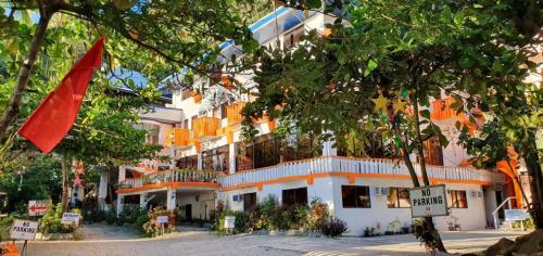 Mt. Bagarabon Beach Hotel في Mabua: مبنى امامه علم احمر