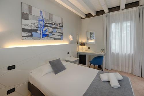 a bedroom with a bed and a desk and a bed sidx sidx sidx at Hotel Fontana Verona in Verona