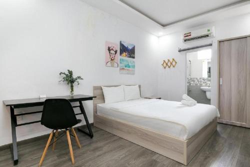 a bedroom with a bed and a desk and a chair at Cactusland Near Tan Son Nhat Airport in Ho Chi Minh City