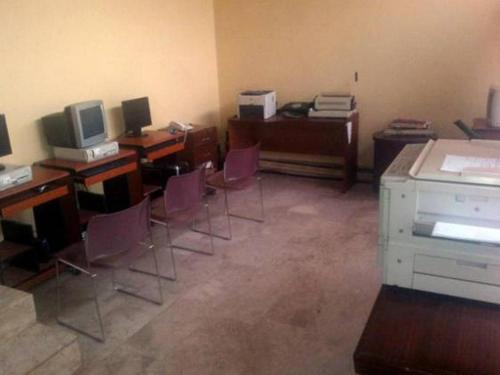 um escritório com secretárias e cadeiras e uma secretária com um computador em Roban Hotels Ltd em Enugu