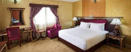 Habitación de hotel con cama grande y espejo en Top Rate Hotel en Owerri