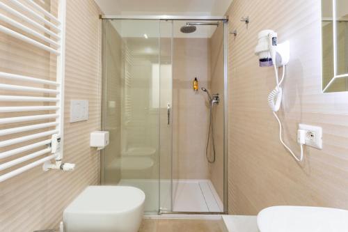 uma casa de banho com um chuveiro, um WC e um lavatório. em FARNESINA SUITE em Roma