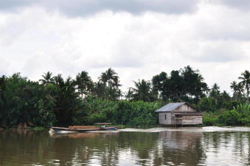 a small shack and a boat on a river at MEGARA HOTEL PEKANBARU in Pekanbaru