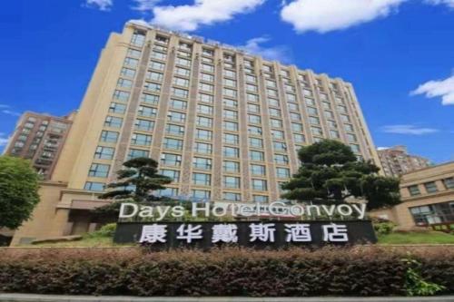 duży budynek z znakiem przed nim w obiekcie Days Hotel by Wyndham Hunan Changsha Convoy w mieście Muyun