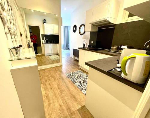 eine Küche mit weißen Schränken und einer Arbeitsplatte in der Unterkunft Cute comfortable apartment with Monaco & sea view in Beausoleil