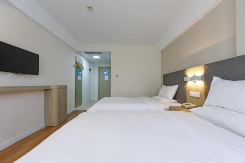 Een bed of bedden in een kamer bij Hanting Hotel Shanghai Railway Station