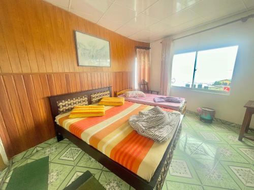 een slaapkamer met 2 bedden en een raam bij Lakshan View Resort in Haputale