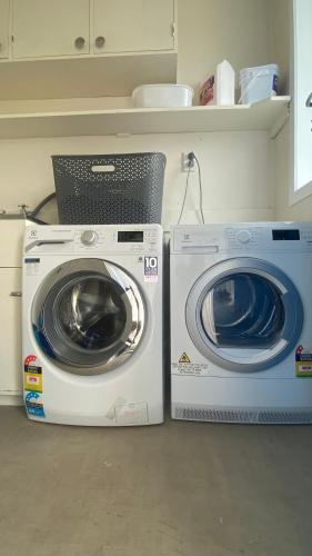 two washing machines sitting next to each other in a kitchen at 3 Bedroom Home by the Reserve in Rotorua