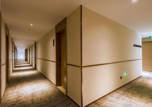 un pasillo vacío de un edificio de oficinas con una fila de puertas en City Comfort Inn Chengdu Dongjiao Memory, en Chengdú