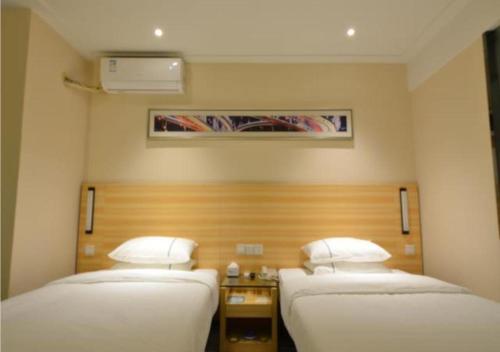Ένα ή περισσότερα κρεβάτια σε δωμάτιο στο City Comfort Inn Wuhan Qingshan Jianshi Qingyiju Metro Station
