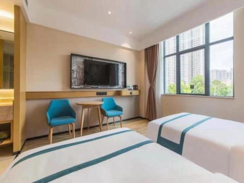 um quarto de hotel com duas camas e uma televisão de ecrã plano em City Comfort Inn Kunming Qianxing Road Dashanghui Children's Hospital em Kunming