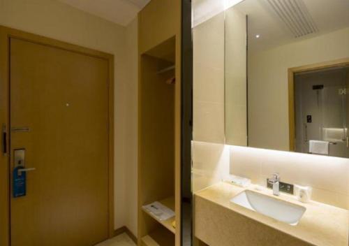 a bathroom with a sink and a mirror at City Comfort Inn Changsha South Railyway Station West Square in Yangtianhu