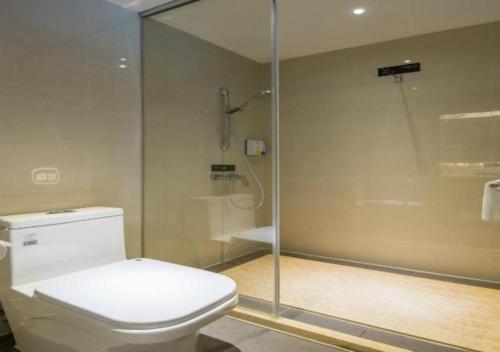 a bathroom with a toilet and a glass shower at City Comfort Inn Changsha South Railyway Station West Square in Yangtianhu