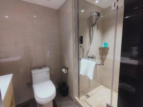 a bathroom with a shower and a toilet and a sink at City Comfort Inn Changsha South Railyway Station West Square in Yangtianhu